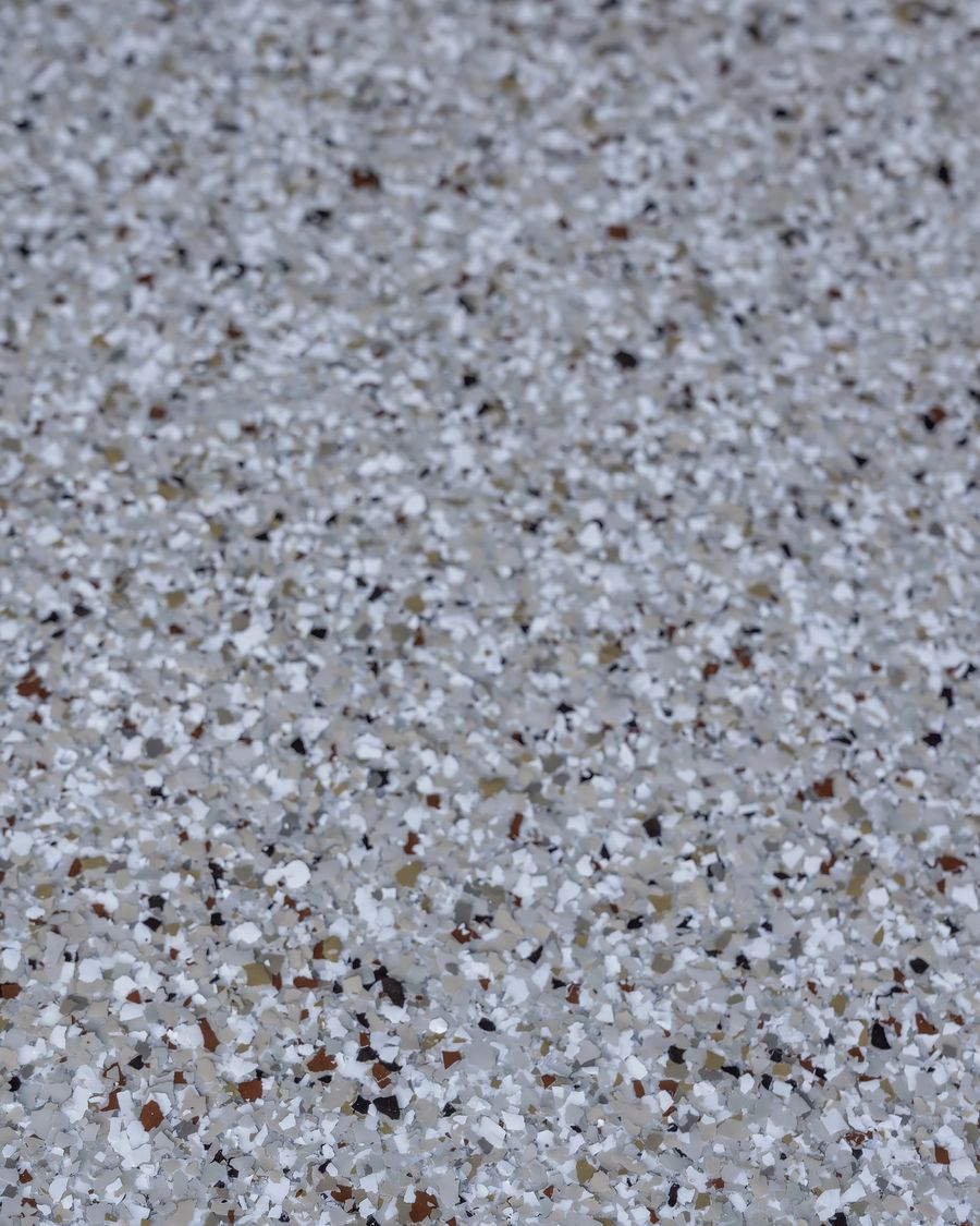 Chip flake surface close up, grey, white and tan flake locked under a clear topcoat